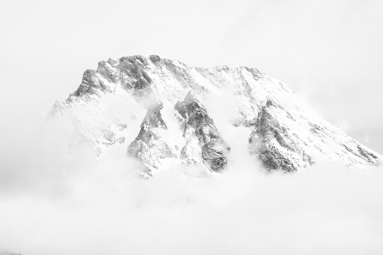 The top half of Mount Moran, partially covered in clouds after a storm.