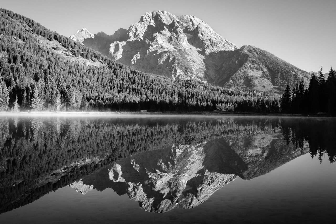Mist rising from String Lake at dawn. Mount Moran looms in the background.