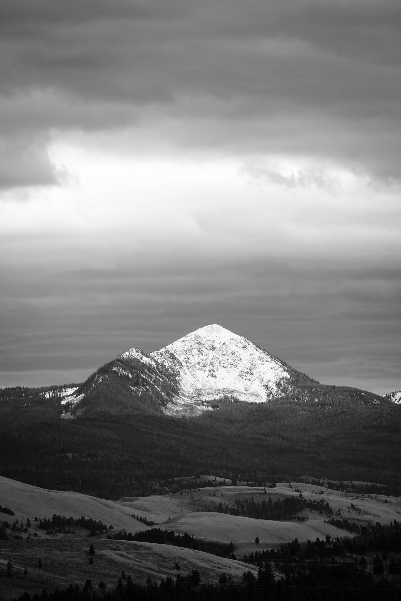 Jackson Peak, seen from Antelope Flats, as a break in storm clouds shines sunlight on it.